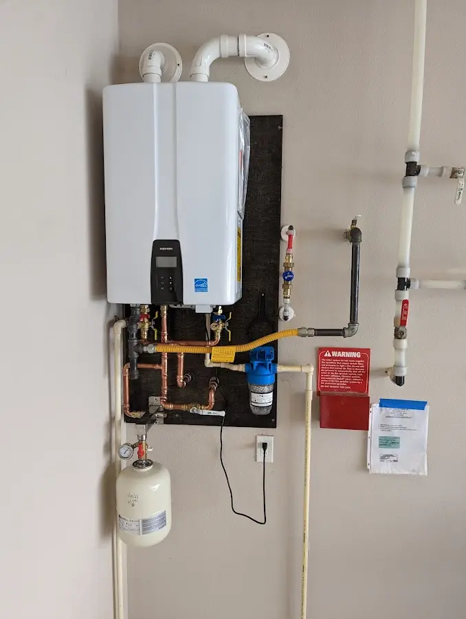 Professional plumber installing copper piping in a West Windsor home